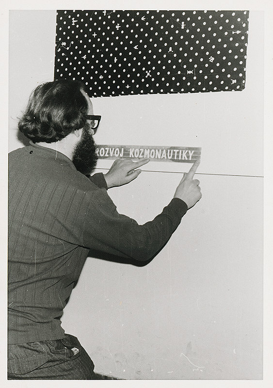 Július Koller – Archív JK/Július Koller aranžuje popisky na výstave "Textilné obrazy 